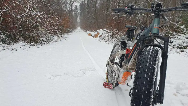 Ein Mountainbike auf Waldweg im Schnee, im Hintergrund Wald - JobRadmoment eines Jobradlers Ein Mountainbike auf Waldweg im Schnee, im Hintergrund Wald - JobRadmoment eines Jobradlers