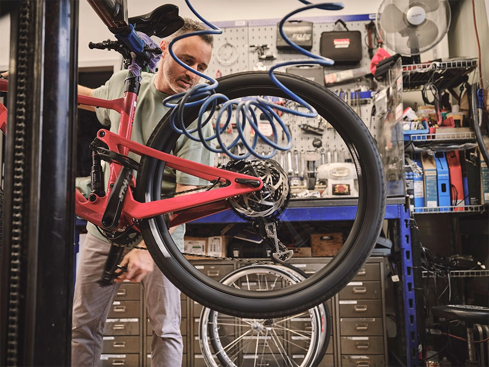 Ein Fachhändler überprüft den Reifendruck eines Fahrrads Ein Fachhändler überprüft den Reifendruck eines Fahrrads